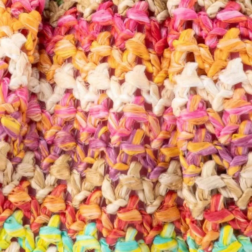 Close-up of multi-colour woven shoe upper fabric with pink, orange, yellow and cream braided texture